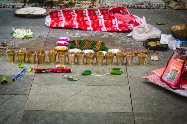 पितृ तर्पण मंत्र — पंडित नदी तट पर पारंपरिक समारोह में मंत्र पाठ करते हुए