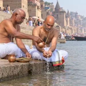Person performing the tarpanam during the asthi pooja at the ganga