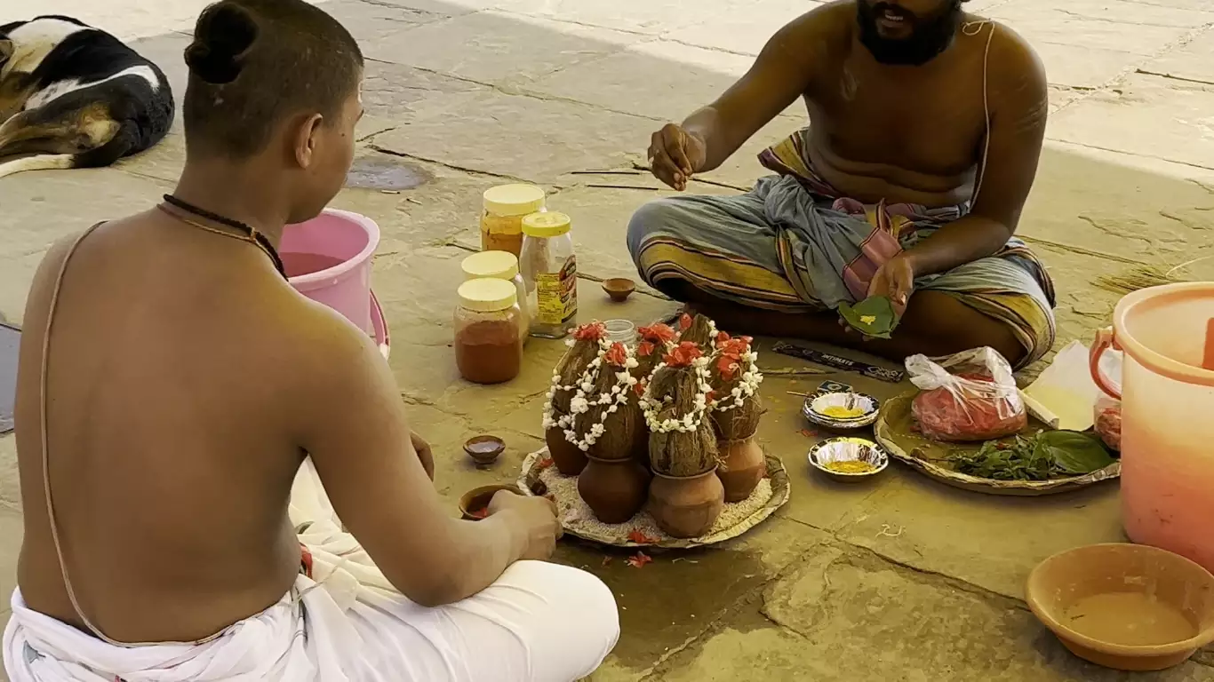 Pandit guiding a participant through Narayan Bali ritual offerings