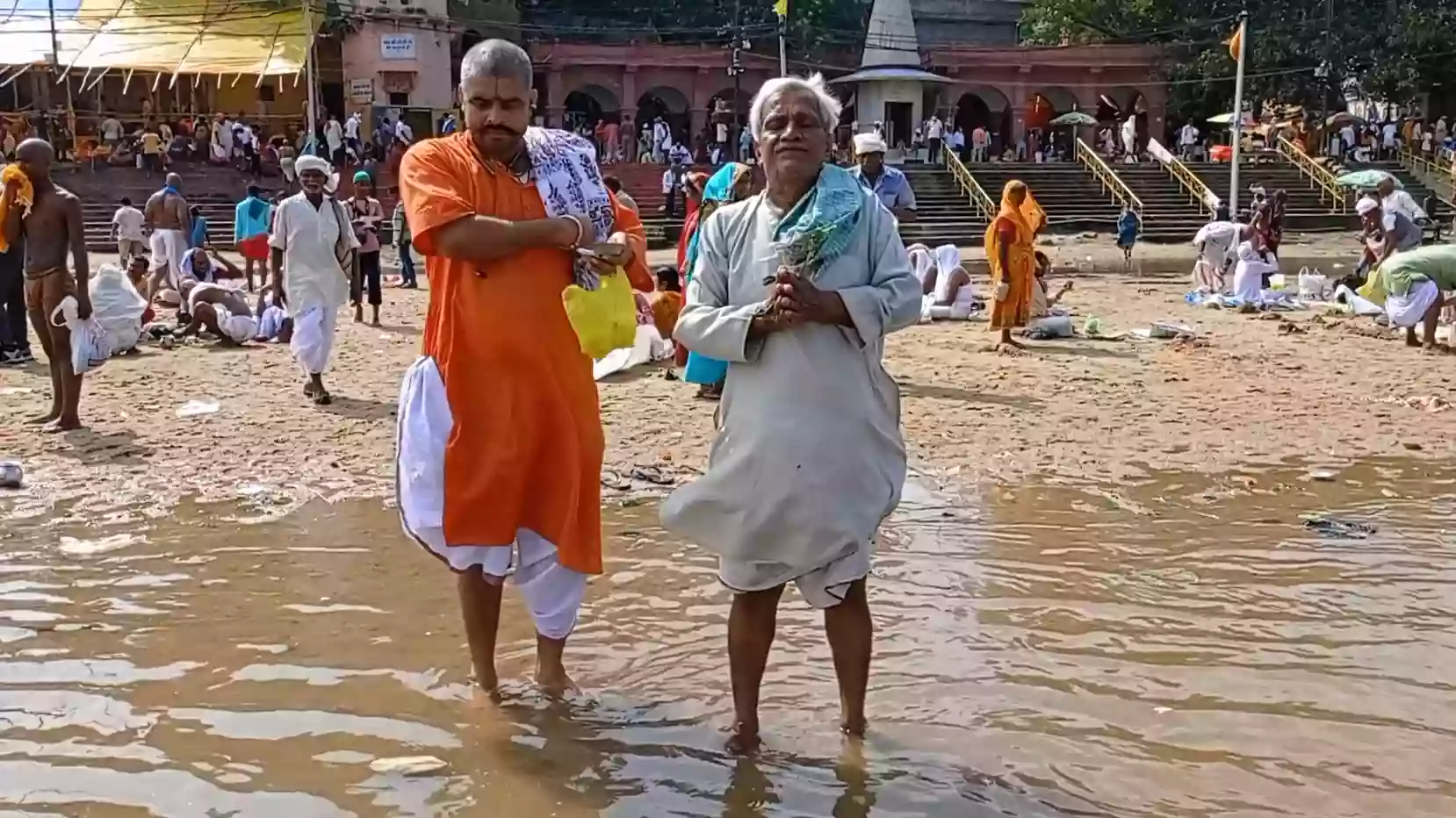 Pandit accompanying a devotee at a sacred ghat for ancestral rites