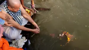 A family performs ancestral rites from a boat, releasing sacred flower offerings into the holy sangam- Pind Daan from Malaysia