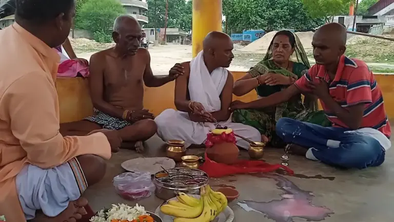 A family performs the ancestral rites together with the pandit, the offerings laid before them